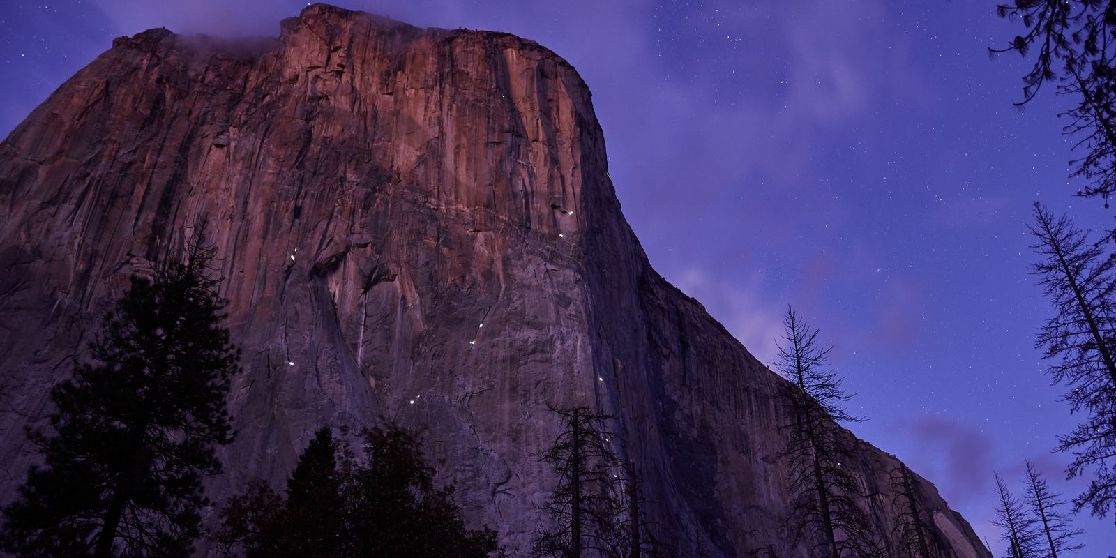El Capitan at night with headlamps of climbers dotting the wall