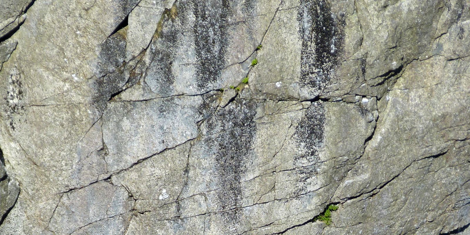 A climber on a steep rock face in Wales without a rope