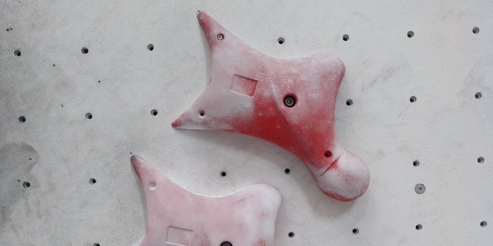 The first holds at the bottom of a red speed climbing wall