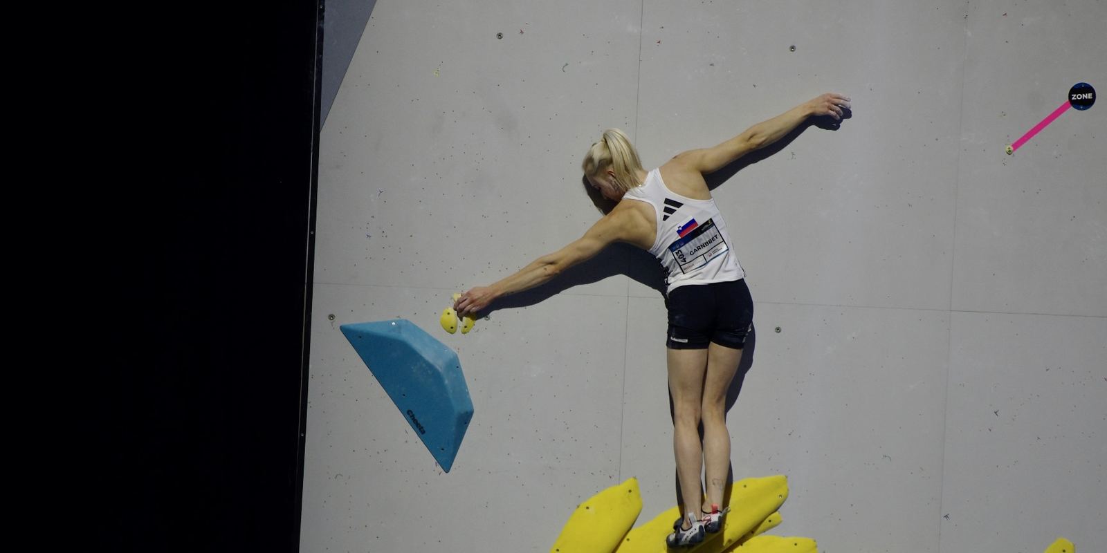 Climber Janja Garnbret reaching for a hold at the 2023 World Championships in Bern